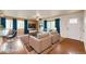 A virtually staged living room has hardwood floors, a rug, and bright accents at 73 N Dutch Valley Rd, Bennett, CO 80102