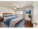 Staged main bedroom with a ceiling fan, wood floors, and natural light at 73 N Dutch Valley Rd, Bennett, CO 80102
