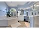 Bright bathroom featuring a soaking tub, and large window with plantation shutters at 2742 S Braun Way, Lakewood, CO 80228