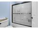 Bathroom featuring a tiled shower with glass door, toilet, and storage area at 2742 S Braun Way, Lakewood, CO 80228