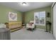 Charming Bedroom featuring a crib, rocking chair, and a bright window with white shutters at 2742 S Braun Way, Lakewood, CO 80228