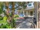 Inviting front porch with seating area and beautifully landscaped yard with mature trees in front of the home at 2742 S Braun Way, Lakewood, CO 80228