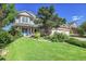Beautifully landscaped front yard with lush lawn and mature trees leading up to a charming two-story home at 2742 S Braun Way, Lakewood, CO 80228