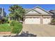 Home featuring a spacious three-car garage and beautifully landscaped front yard with mature trees at 2742 S Braun Way, Lakewood, CO 80228