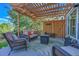 Cozy outdoor patio is complete with cushioned seating, a fire pit, and overhead pergola at 2742 S Braun Way, Lakewood, CO 80228