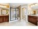 Spacious bathroom featuring dual vanities, tile flooring, and a glass-enclosed shower with a built-in bench at 6043 S Paris St, Greenwood Village, CO 80111