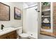 Bathroom with a stand-up shower with white subway tile, wood vanity, and decor at 6043 S Paris St, Greenwood Village, CO 80111