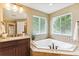 Bright bathroom boasts a soaking tub with tile surround and large windows for natural light at 6043 S Paris St, Greenwood Village, CO 80111