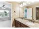 Bright bathroom featuring dual sinks, granite counters, and a view to the bedroom at 6043 S Paris St, Greenwood Village, CO 80111