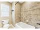 Functional bathroom showcases tiled tub and shower, toilet, and a bright window at 6043 S Paris St, Greenwood Village, CO 80111