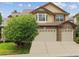 Two-story home featuring a three car garage, bay window, brick accents and manicured lawn at 6043 S Paris St, Greenwood Village, CO 80111