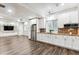 Open-concept kitchen featuring white cabinets, stainless steel appliances, brick backsplash, and wood-look floors at 6043 S Paris St, Greenwood Village, CO 80111