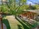 Aerial view of backyard featuring artificial turf, covered patio, mature shade trees, and a treehouse at 2235 Edgewood Dr, Boulder, CO 80304