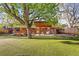 Spacious backyard featuring a covered patio, manicured lawn, mature trees, and a custom treehouse at 2235 Edgewood Dr, Boulder, CO 80304