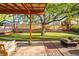 Backyard with a covered patio area, artificial turf, and mature landscaping at 2235 Edgewood Dr, Boulder, CO 80304