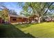 Serene backyard with artificial turf, covered patio, and mature trees offering shade at 2235 Edgewood Dr, Boulder, CO 80304