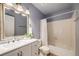 Bathroom featuring a double sink vanity, large mirror, and a tub with shower at 3870 S Ouray Way, Aurora, CO 80013