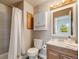 Bathroom features wooden cabinets, white tiling and sink, medicine cabinet, and shower with white curtain at 3870 S Ouray Way, Aurora, CO 80013