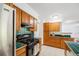 Kitchen featuring tile countertops, wood cabinets, updated appliances and white tile floors at 3870 S Ouray Way, Aurora, CO 80013