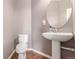 Powder room featuring hardwood floors, pedestal sink, and an oval mirror at 129 N Irvington St, Aurora, CO 80018