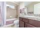 Bathroom with a shower-tub, vanity with granite counters, and large mirror at 129 N Irvington St, Aurora, CO 80018