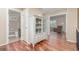 Hallway with hardwood floors, curio cabinet, and doorways to a bathroom and living room at 129 N Irvington St, Aurora, CO 80018