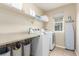 Functional laundry room with shelving, folding table, washer and dryer, and a window at 129 N Irvington St, Aurora, CO 80018