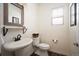 A bathroom features modern fixtures with a pedestal sink, toilet, accent mirror and built in shelf at 3834 Donnington Cir, Castle Rock, CO 80104