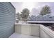 View from the balcony showing snow-covered trees and the complex carport parking area at 266 S Nome St, Aurora, CO 80012