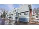 Exterior view of townhomes with blue siding, garages, and well-maintained landscaping at 266 S Nome St, Aurora, CO 80012