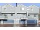 View of townhome exteriors, each featuring a garage, small balcony and neutral siding at 266 S Nome St, Aurora, CO 80012