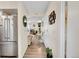 Long hallway view with stainless steel refrigerator, wood floors, and a glimpse of the living room beyond at 266 S Nome St, Aurora, CO 80012
