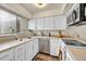 Bright kitchen featuring white cabinets, stainless steel appliances, and a large window for natural light at 266 S Nome St, Aurora, CO 80012