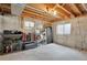 Unfinished basement with exposed wooden beams, concrete walls and floors, and metal shelving for storage at 16750 E Prentice Ave, Centennial, CO 80015