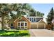 Inviting two-story home with a brick facade, attached two-car garage, mature trees and a well-manicured lawn at 16750 E Prentice Ave, Centennial, CO 80015