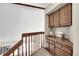 Upper hallway landing features carpet, natural wood railings and built in storage cabinets at 16750 E Prentice Ave, Centennial, CO 80015