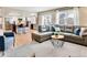 Open-concept living room showcasing a modern kitchen, hardwood floors and comfortable seating near natural light at 16750 E Prentice Ave, Centennial, CO 80015