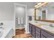 Bathroom featuring wood floors, double sink vanity, framed mirror, and tub at 154 Falcon Cir, Mead, CO 80542