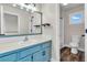 Bathroom with blue vanity, shower, and a view from the window at 154 Falcon Cir, Mead, CO 80542