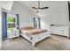 Bright bedroom with vaulted ceiling, ceiling fan, carpet, and two windows at 154 Falcon Cir, Mead, CO 80542
