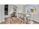 Dining room with wood floors next to a living room with a fireplace and outside views at 154 Falcon Cir, Mead, CO 80542