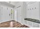 Inviting entryway with wood floors, white bench and storage, and bright lighting at 154 Falcon Cir, Mead, CO 80542