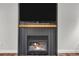 Elegant fireplace with a mounted television, rustic mantel and modern black shiplap at 154 Falcon Cir, Mead, CO 80542