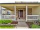 Charming covered front porch with white columns, brick accents and a cozy seating area at 154 Falcon Cir, Mead, CO 80542
