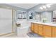 Bright bathroom featuring a walk-in shower, soaking tub, double vanity, and a large window at 492 E 131St Ave, Thornton, CO 80241