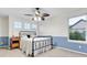 Cozy bedroom featuring a decorative ceiling fan, neutral color scheme, and large window at 492 E 131St Ave, Thornton, CO 80241