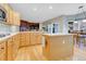 Spacious kitchen with wood floors, central island, stainless steel appliances, and a view to the fireplace at 492 E 131St Ave, Thornton, CO 80241