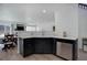 Bright kitchen area with stainless steel dishwasher and dark cabinets, open to the dining area at 1203 S Zeno Way # C, Aurora, CO 80017