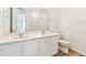 Bathroom with a dual sink vanity, toilet, and mirror at 9742 Cathay St, Commerce City, CO 80022