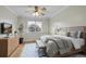 Bright bedroom with a large window, ceiling fan, light wood floors, and a comfortable bed with a grey comforter at 783 Eudora St, Denver, CO 80220